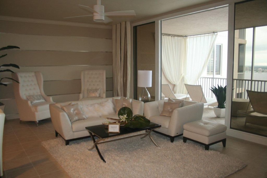 Bright modern living room with beige sofas, large windows, and a coffee table.