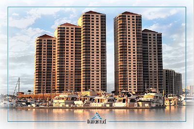 Modern high-rise apartment towers and waterfront marina at dusk with a clear sky.