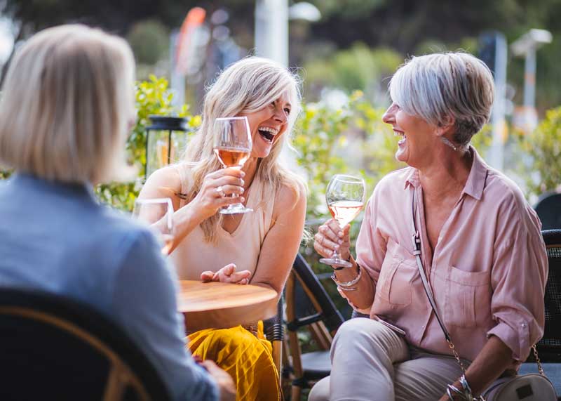 three older ladies having drinks outside