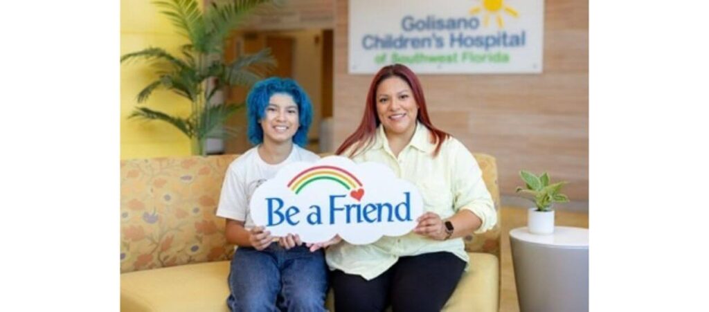 Two women hold a sign reading “Be a Friend” in the Golisano Children’s Hospital.